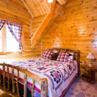 спалня в дървена къща със завеси