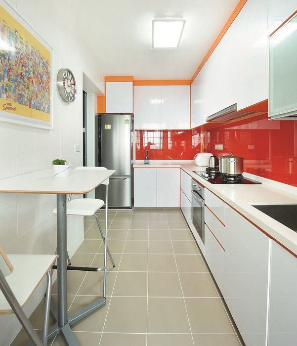 Rött glänsande förkläde i ett vitt kök