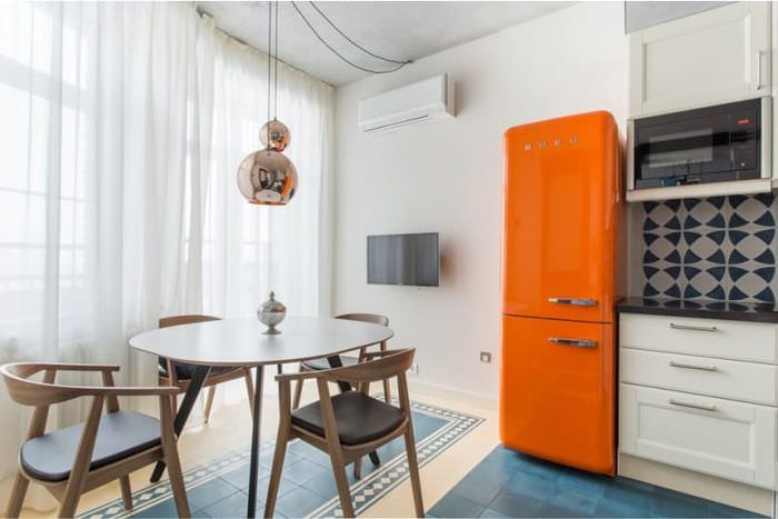 Hvitt kjøkkendesign med oransje kjøleskap