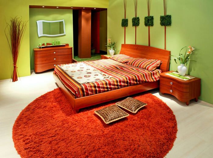 Oranžová posteľ a koberec v interiéri spálne