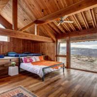 Soverom med panoramavindu i et hus av tømmer