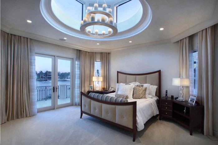 Helles Schlafzimmer mit dunklem Bett im neoklassizistischen Stil