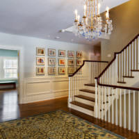 Holztreppe mit weißem Geländer im Foyer eines Landhauses