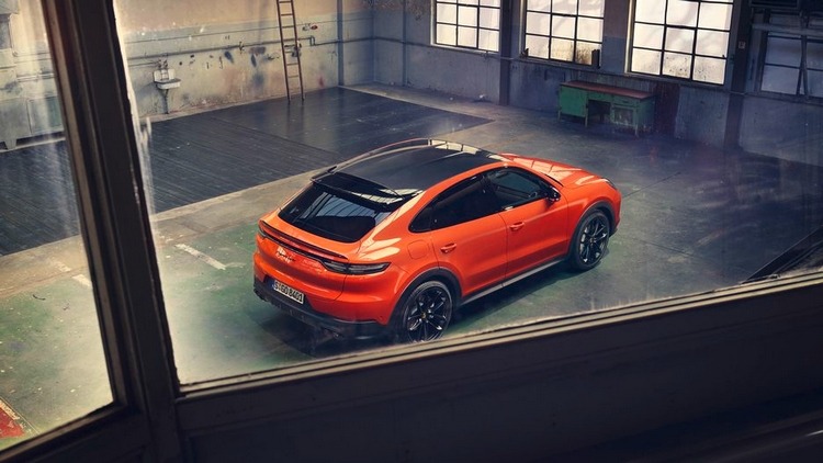 porsche cayenne coupe i orange med sort glastag i rustikke omgivelser