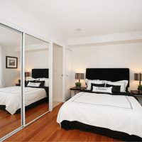 Zrkadlová stena v spálni s bielou posteľou