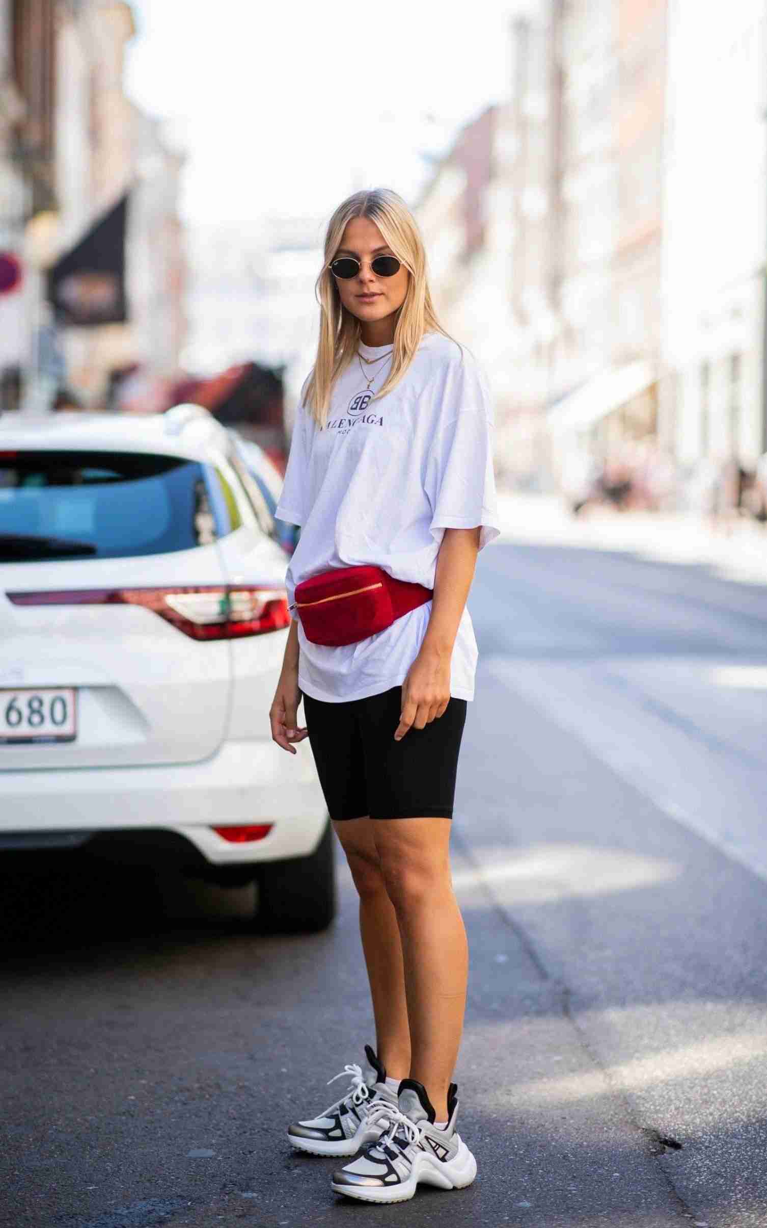 Cykelshorts kombinerer t-shirt bæltetaske røde læder sneakers solbriller omkring modetrends