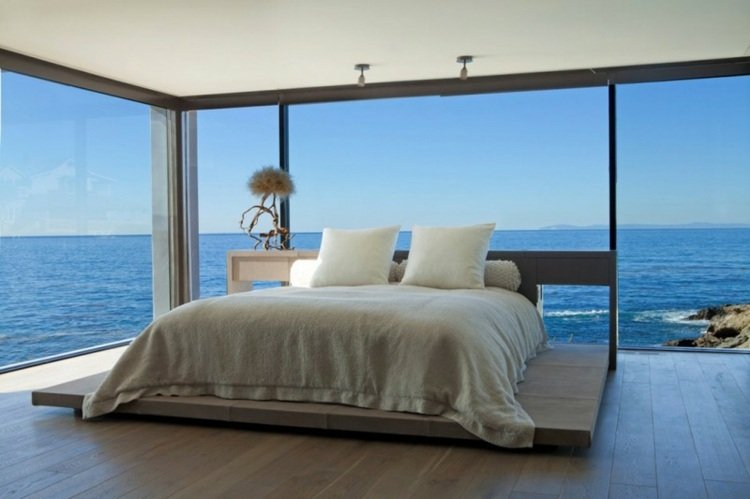 soveværelse med udsigt over havet blågrå sengelinned natbord
