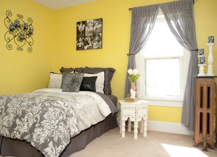 Priesvitné sivé závesy v spálni so žltými stenami