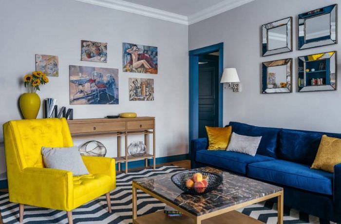 كرسي بذراعين أصفر في غرفة المعيشة مع أريكة زرقاء