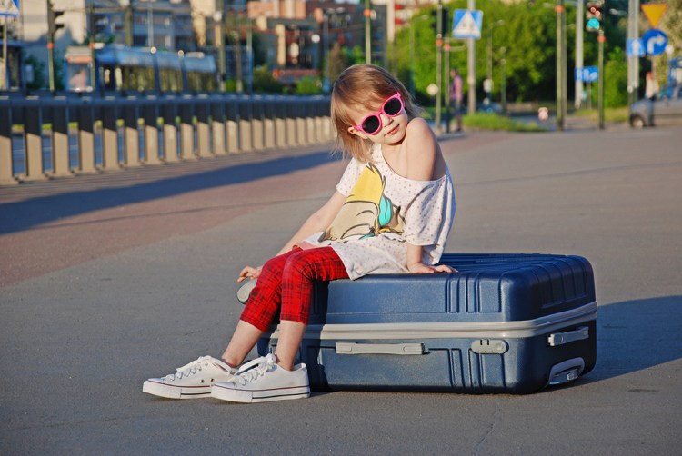 Ferie med børnepige, der sidder på kuffert, hvad du skal være opmærksom på