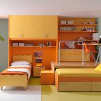 kombinasjonen av lys oransje i utformingen av kjøkkenet med andre farger på bildet