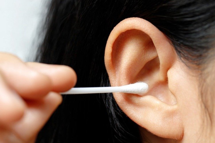 kvinde fjerner ørevoks med vatpinde