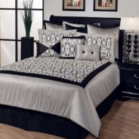 Schwarzes Bett mit weißer Tagesdecke im Schlafzimmer einer Stadtwohnung