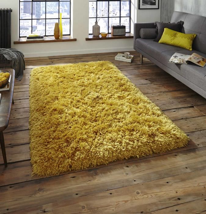 Gelber Teppich auf Holzboden im dunklen Schlafzimmer