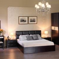 Schwarzes Bett mit weißer Tagesdecke in einem Raum mit hellen Wänden