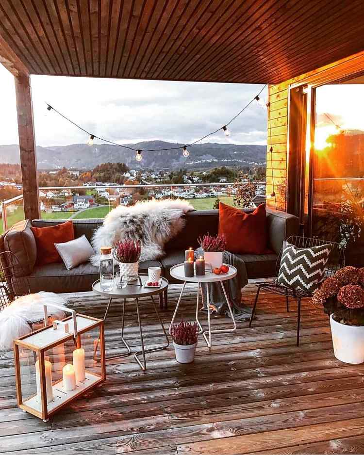 Dekorer terrassen om efteråret med pyntepuder i murstenrødt og levende lys
