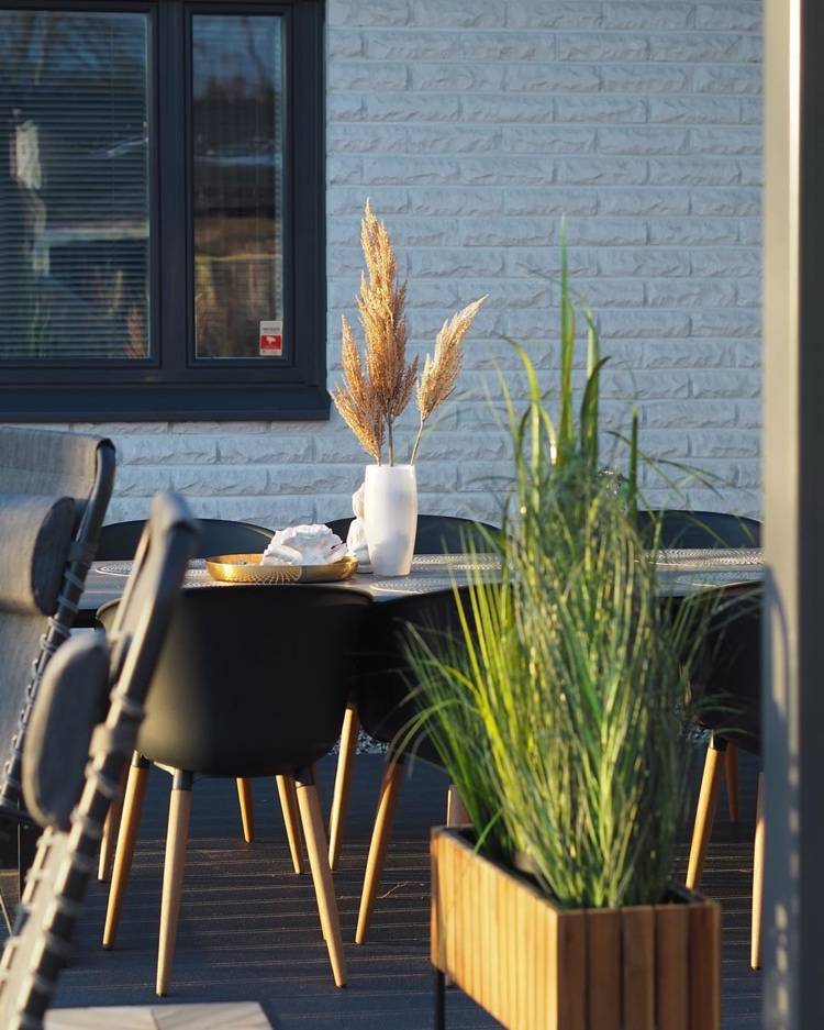 tørrede græsser i en vase på det udendørs spisebord