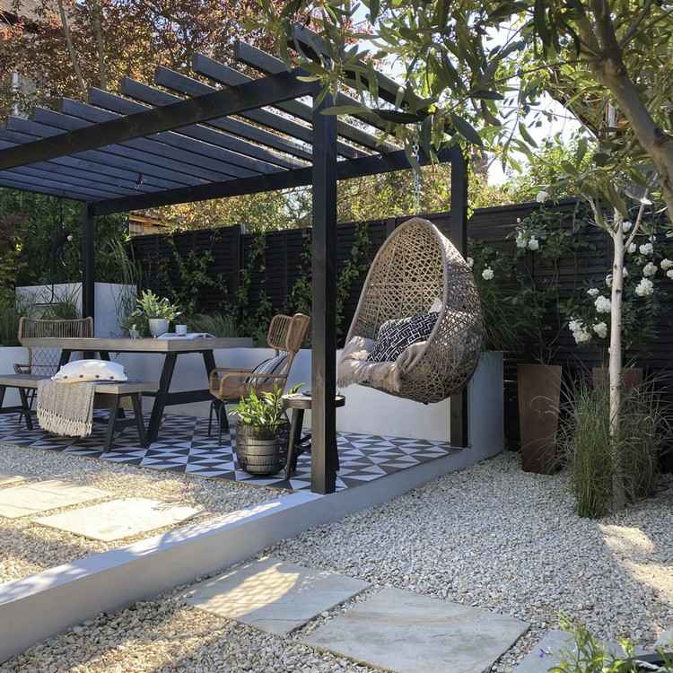 Design en moderne terrasse i haven med spiseplads og hængestol