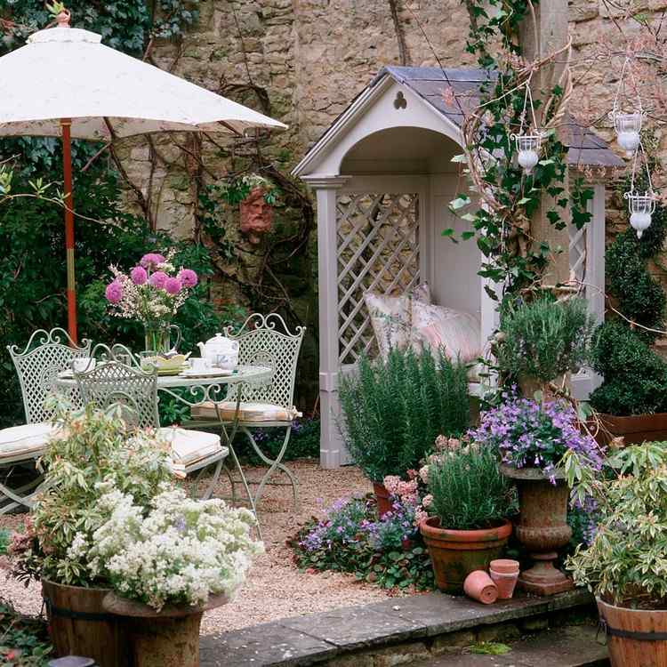 Romantisk have i hytte-stil med en lille terrasse og et lille hus