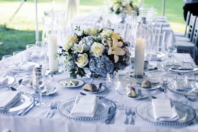 bordpynt til bryllup blå accenter blomsterarrangement lys glasplader