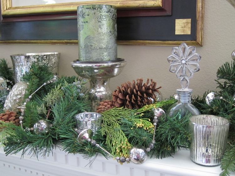 borddekoration-jul-sølv-grønne-grene-kaminhylde-selvfølgelig-kegler-lanterner