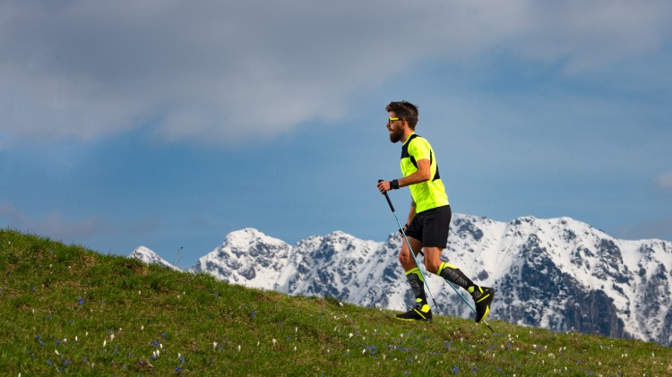 mand, der holder trail løbestokke, mens han kører i bjerge