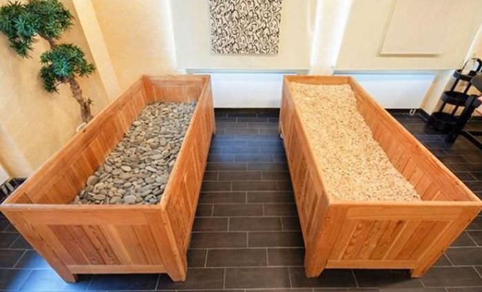 Drevené boxy s kamienkami a pilinami v japonskej saune