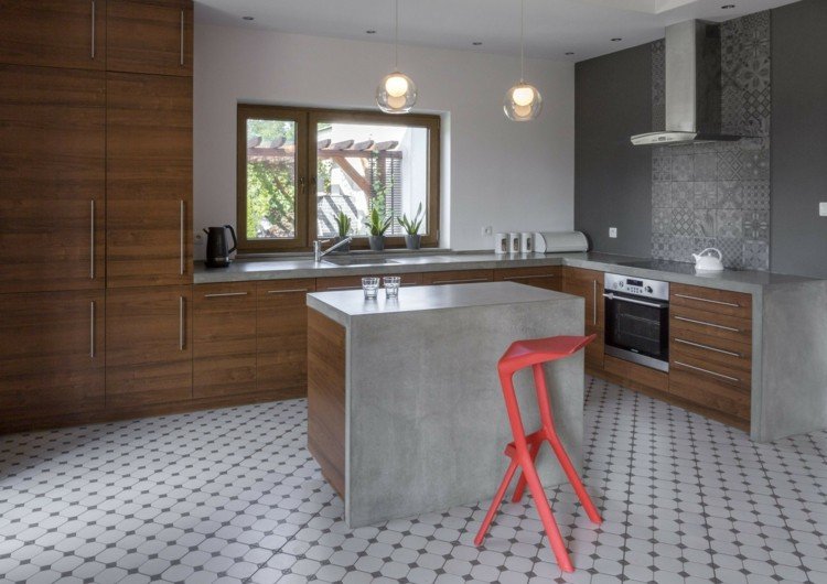 Rummeligt køkken med betonlook med en lille køkkenø og patchwork stænkskærm