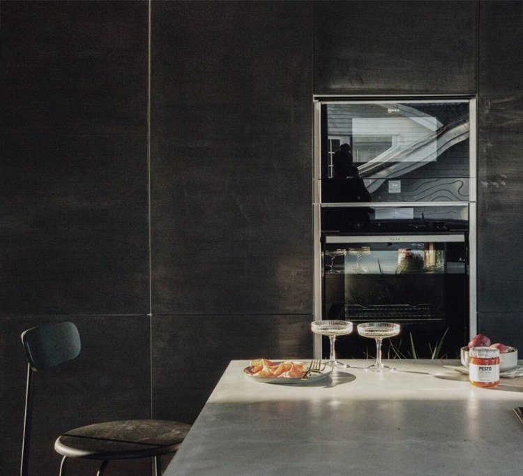 Sort beton ser ud som køkkenfronter og ovn i det høje skab