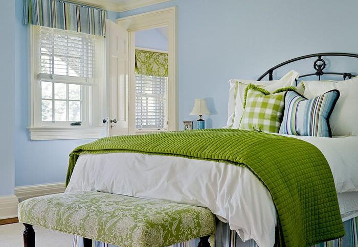 Zelený prehoz na posteľ v spálni s modrými stenami