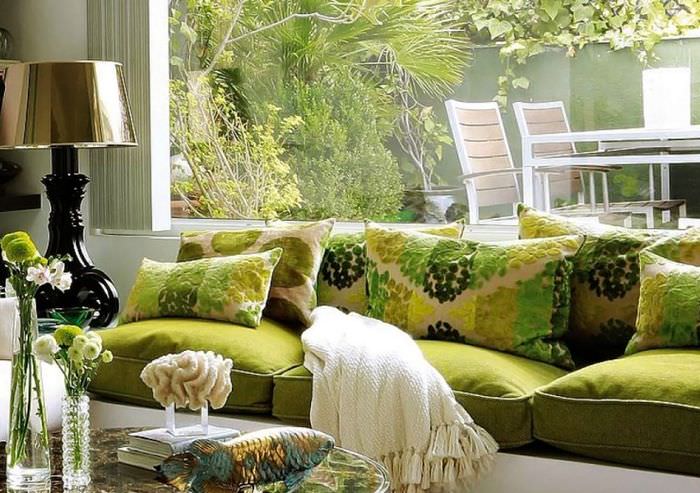 Zelená pohovka pred oknom obývačky v súkromnom dome