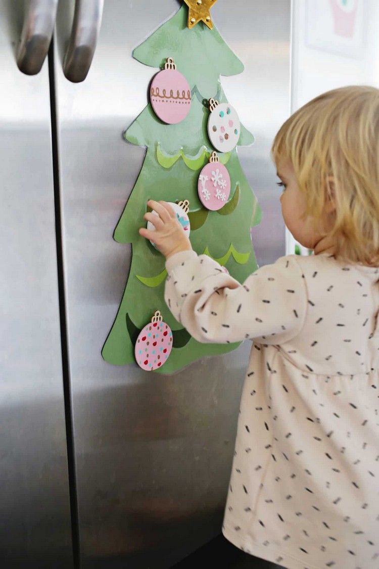 Julehåndværk med småbørn 2 -årigt barn pynter DIY juletræ