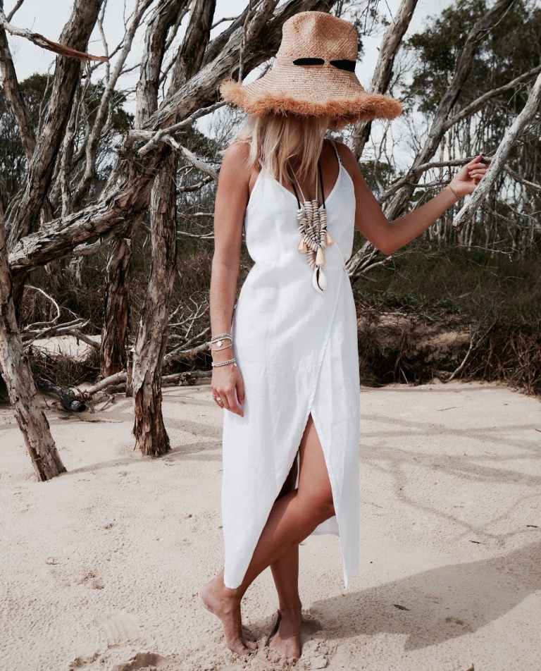 Kjole i linnedvikling kombinerer sommer strandtøj halm hat boho look