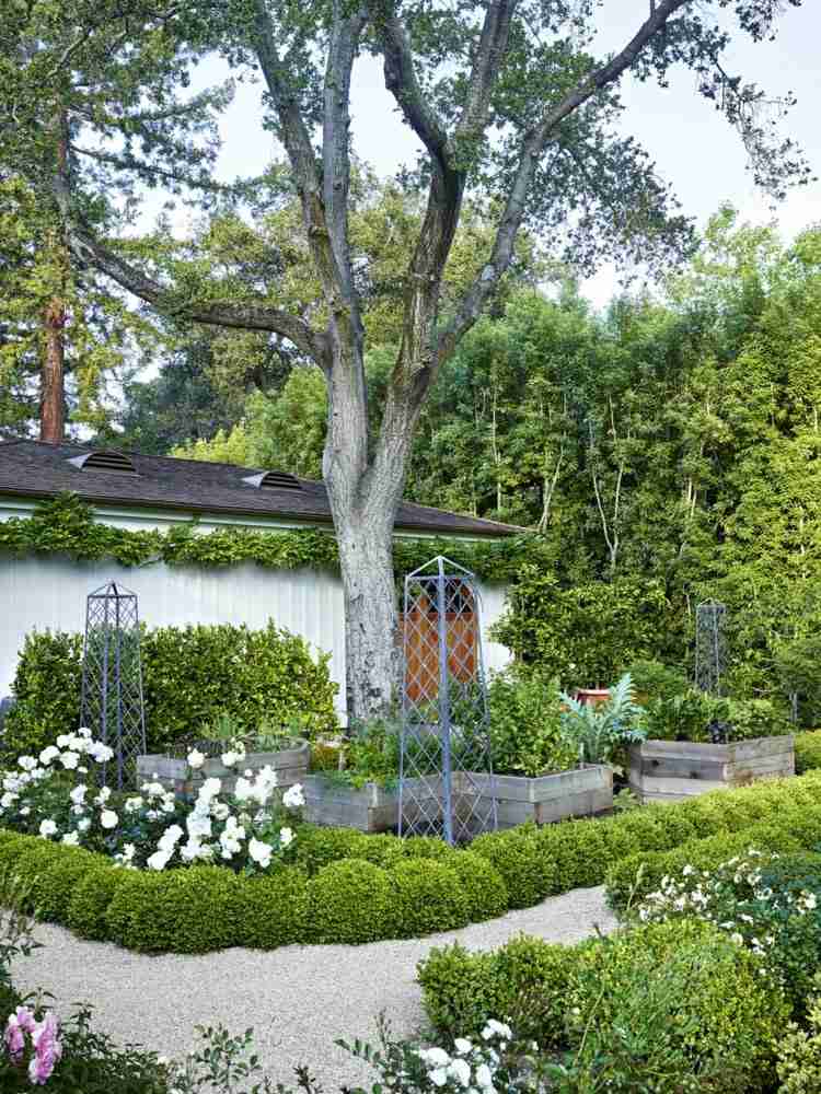 Højbed og grusstier med hvide blomster og kassetræer