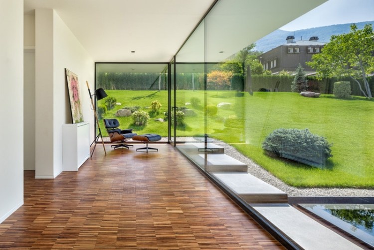 glas-væg-inde-uden-lys-bambus-gulv-panorama-have-lænestol-udsigt