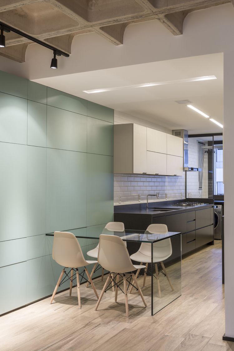 Konvertering af lejlighed Køkken og stue er forbundet med et udtrækkeligt glasbord, væggenhed og et moderne gallerikøkken