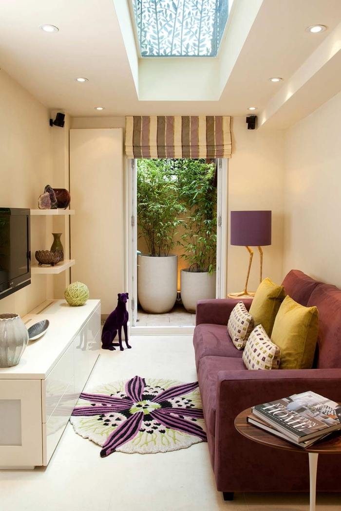 Indretning af en smal stue lilla-farvet 2-personers sofa-tv-vægmonteret